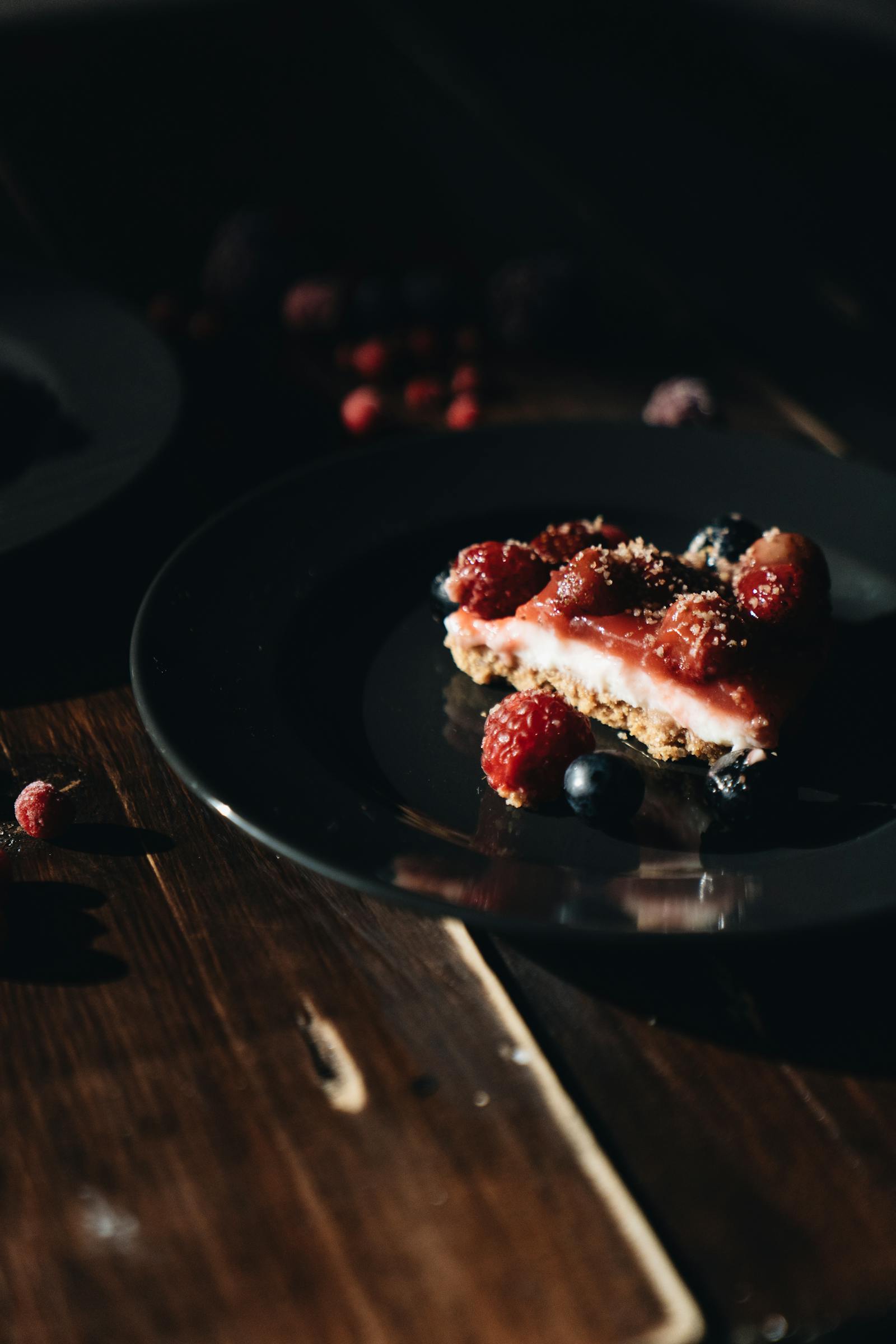 A bowl of saffron risotto on a rough ceramic plate, shot from above with a long shadow, deep umber palette.